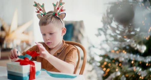 Little Boy Opening Christmas Gift at Home