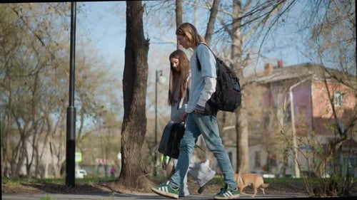 Youthful Individuals Freely Wandering Through Bright Park Environment Pair of Young Persons Ambling
