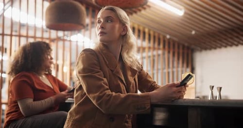 Woman, waiting and phone at bar for date, texting and frustrated thinking with cocktail