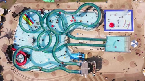 Top down aerial footage of a large and crowded Water park.