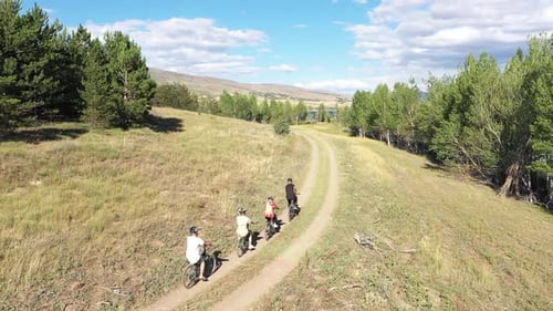 Vidéo aérienne de personnes faisant de l'exercice à vélo dans une forêt près du lac