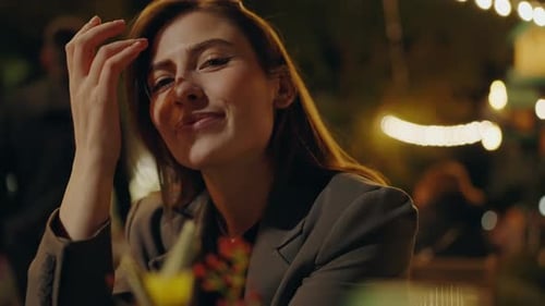 Schöne Frau sitzt am Café-Tisch bei einem romantischen Date am Abend