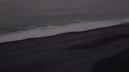 Lone Walker on a Black Sand Beach in Iceland
