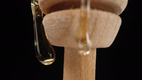 Honey Dripping from Wooden Dipper Close Up