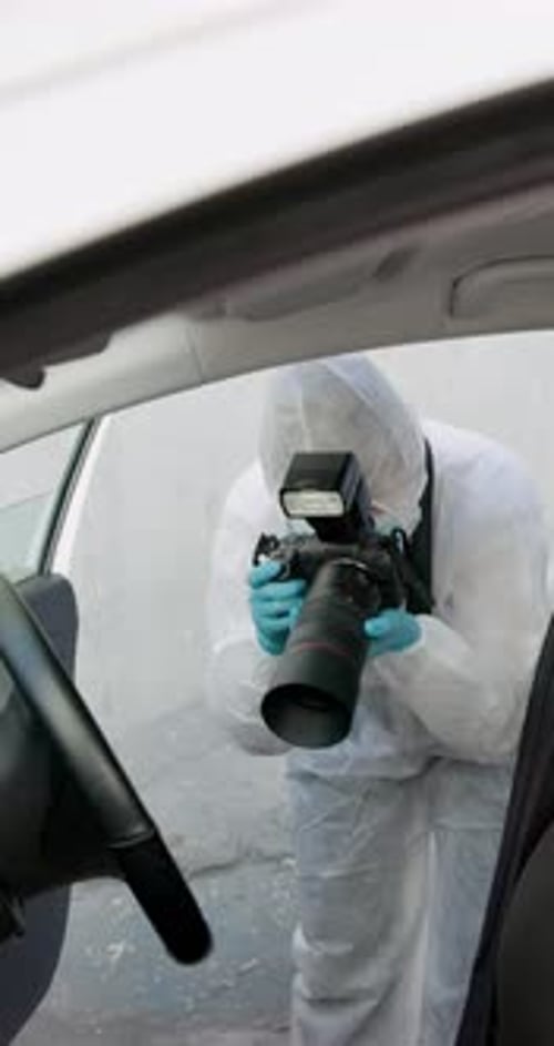 Photographer in Protective Suit Investigating Car Interior