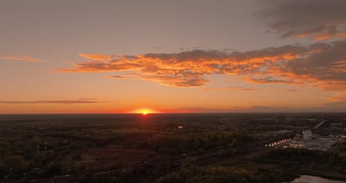 Aerial wide shot gold sunset, sun at the horizon line, golden clouds, HDR 4K50Fps