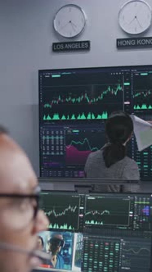 Analysts Analyze Market Charts on Big Screens