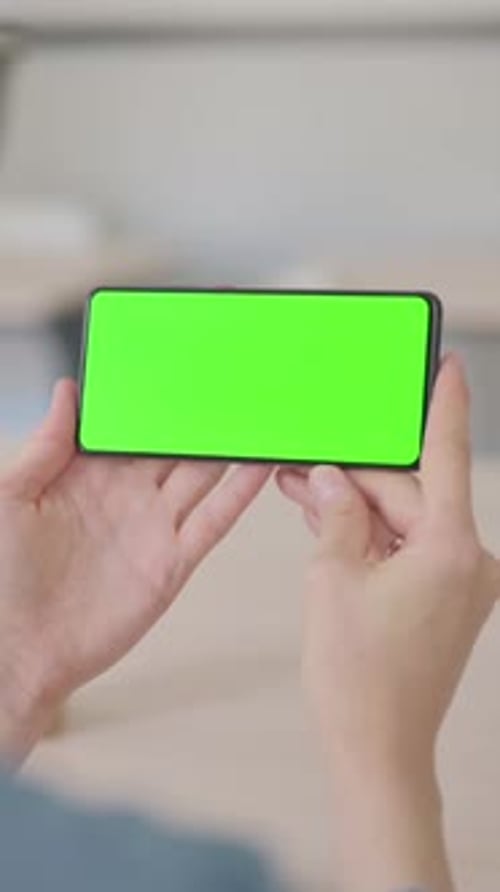 Young Woman Holding Smartphone with Green Screen, Vertical Video