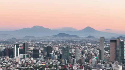 Drone shot of mexico city with volcanoes in sight