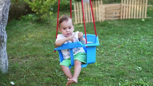 Lovely boy in white t-shirt and green shorts outdoors.