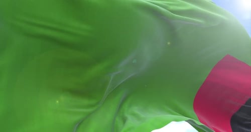 Realistic Zambia Flag Waving Against Blue Sky