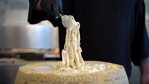 Chef Lifts Pasta from Parmesan Cheese Wheel