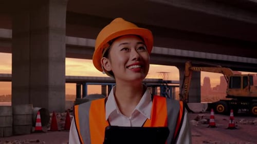 Close Up Of Asian Female Engineer Looking At The Tablet In Her Hand At Building Site