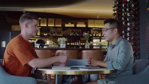 Business Partners Shaking Hands at Cafe Table