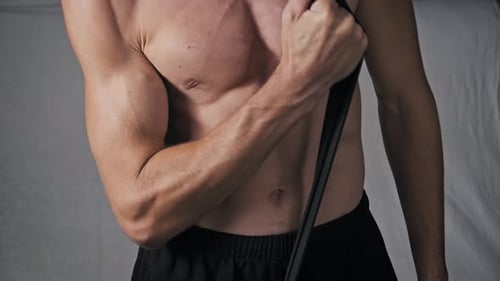 Muscular Man Performing Bicep Curls With Resistance Band