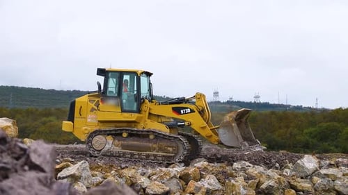 Yellow Excavator Moves Over Rocky Terrain