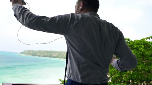Businessman Listening to Music on Cellphone and Dancing on Terrace Adult