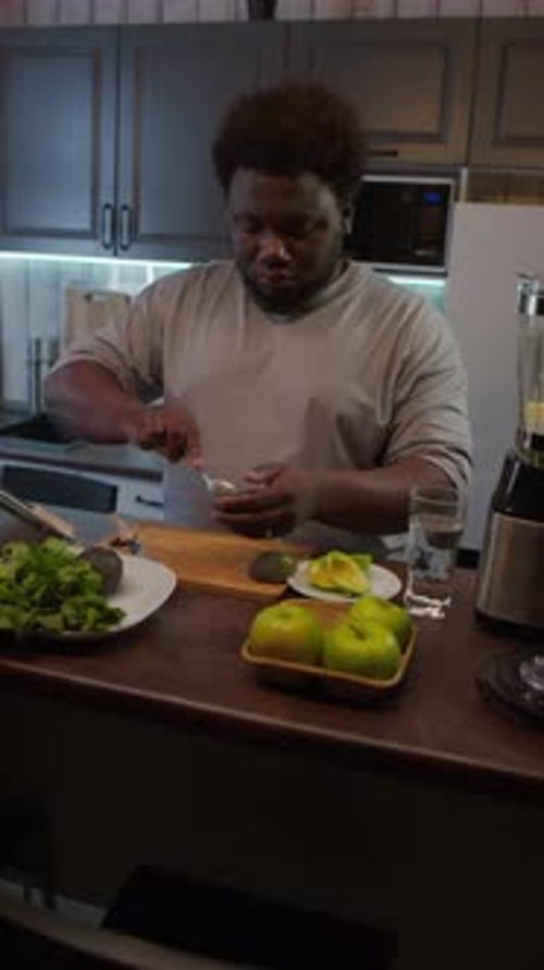 Man Prepares Avocado Smoothie in Modern Kitchen