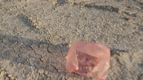 Una bolsa de plástico vuela en tierra seca: desastre ambiental