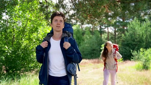 Couple of Young Campers Enjoys Walking Together in Forest
