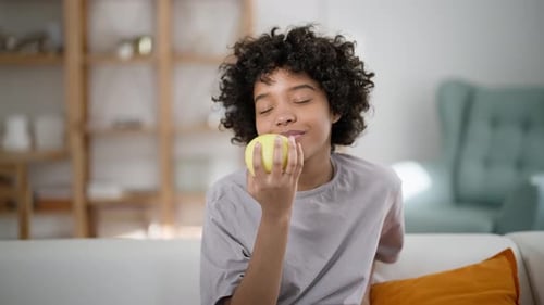 Young Adult Eating a Fresh Apple Indoors