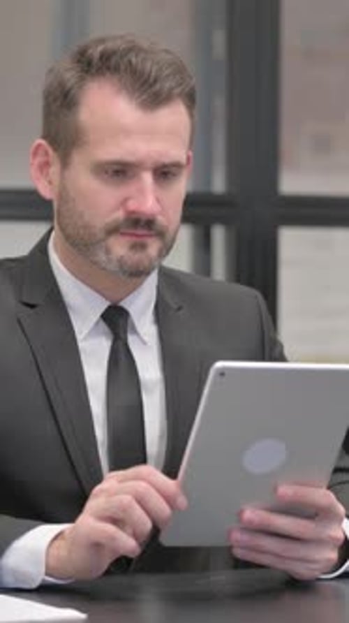 Businessman Using Tablet Device in the Workplace