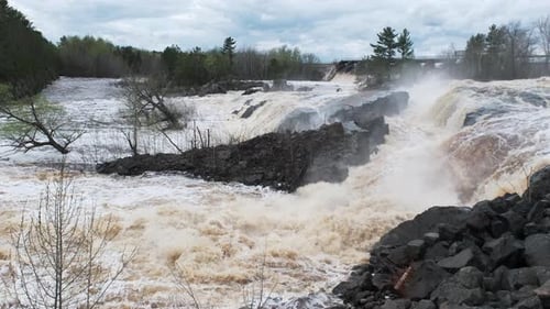springtime flooding, rushing river water around a local dam