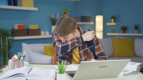 Student Studying and Coughing at His Desk