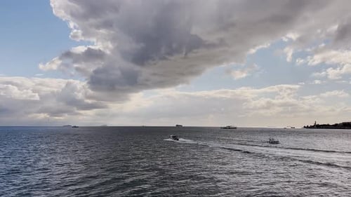 Ferries, boats, sailboats, birds, breakwater, pier, waves in the sea in cloudy weather in autumn