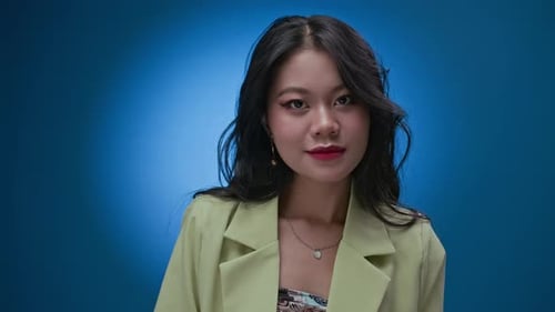 Smiling Woman Styling Hair Against Blue Backdrop