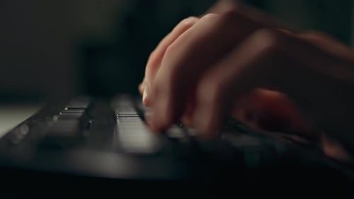Arbeitsablauf eines Mannes an einem Tisch mit einem Laptop, dessen Hände sich geschickt auf der Tastatur bewegen und formen