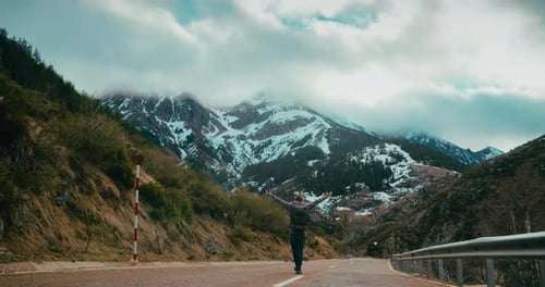 Man Walk on Empty Mountain Road Rising Hands on Vacation Journey Adventure