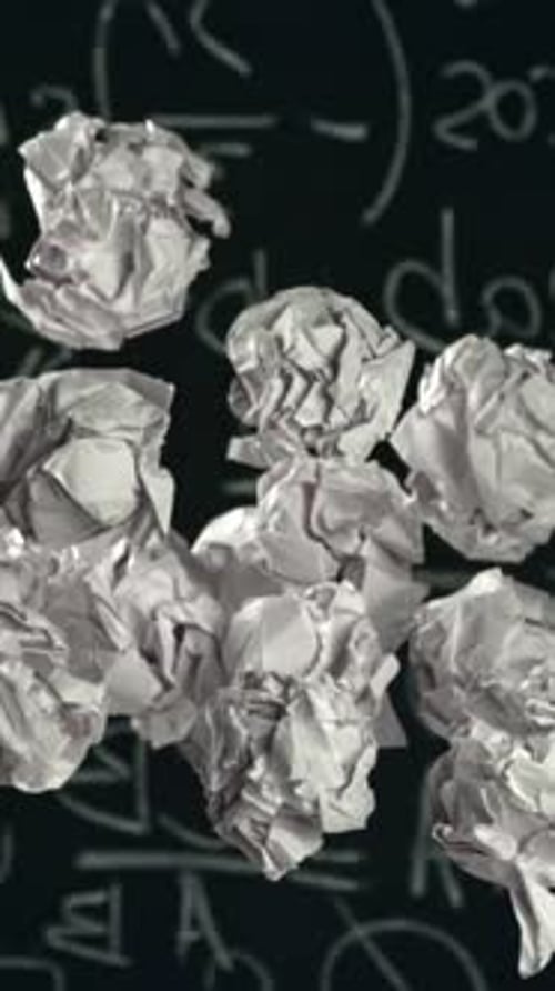 Crumpled Paper Rises and Falls Against the Background of the Blackboard Filmed on a Highspeed Camera