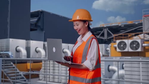 Side View Of Asian Female Engineer Working On A Laptop On Rooftop HVAC