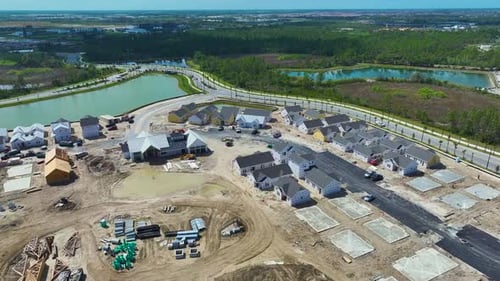 View From Above of Unfinished Frames of Inexpensive Homes with Wooden Roof Beams Under Construction