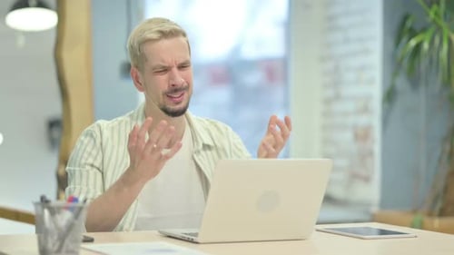 Man With Blond Hair Frustrated With Computer