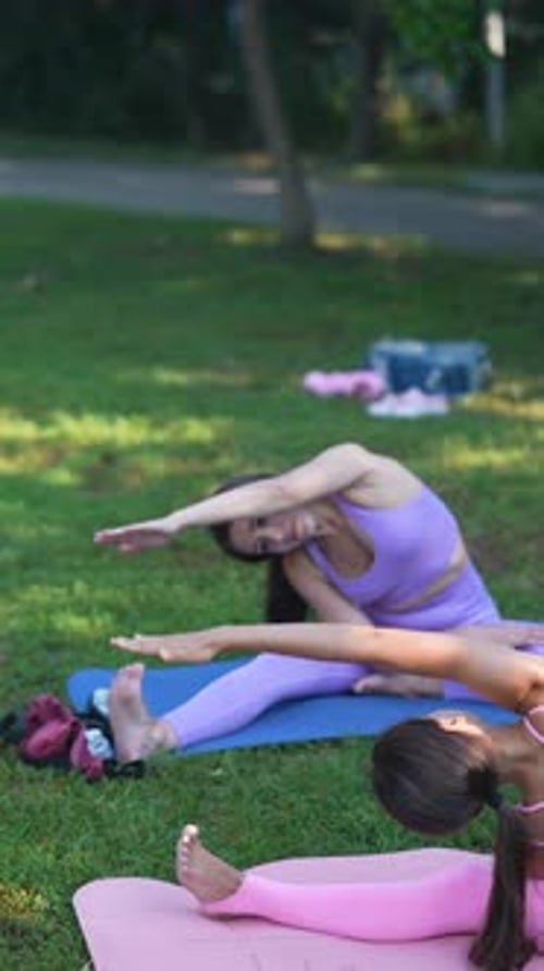 In the Summer Park a Beautiful Mother and Her Athletic Daughter are Engaging in Sports