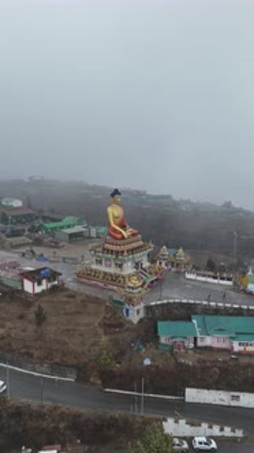 Vue aérienne de la statue géante de Bouddha doré au monastère de Tawang dans les montagnes brumeuses de l'Himalaya