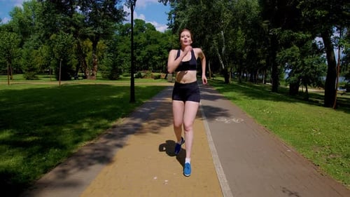 Active Motivated Sporty Fit Woman Jogging on Park Road in Summer
