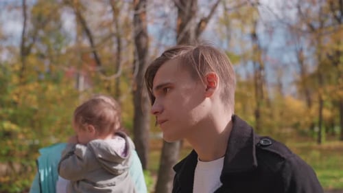 Parents and Child Outdoors Parents and Infant Sharing Crisp Autumn Park Moment Candid Depiction of