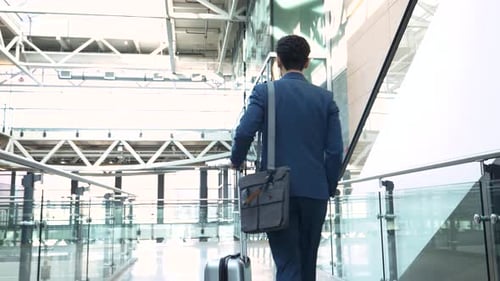 Businessman Rolling Suitcase in Airport Atrium 4044 Years