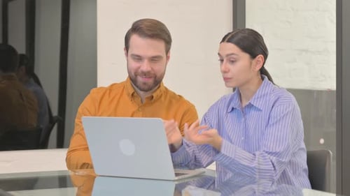 Man and Woman Video Conferencing at Office Desk