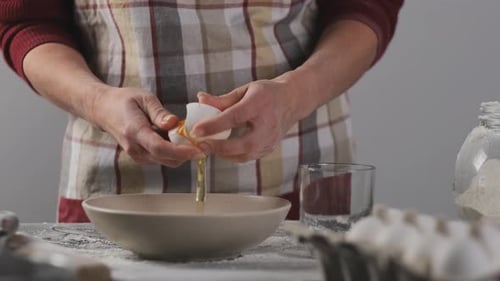 Adult Cracking Egg Into Bowl for Baking