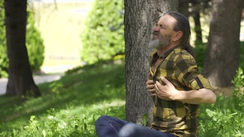 Man with chest pain is in the park. Man with health problem.