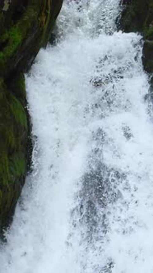 Rauschende Wasserkaskaden, die felsiges Gelände in einer üppigen Waldumgebung hinunterstürzen