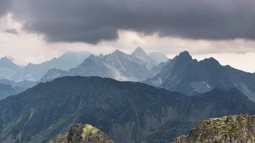 Majestic mountain ranges shrouded in dramatic clouds and shadows at twilight
