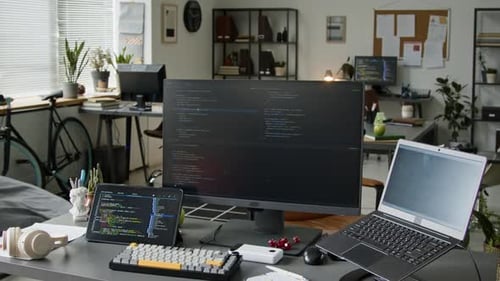 Schreibtisch eines Backend-Softwareentwicklers mit Code auf Laptop, Computer und Tablet