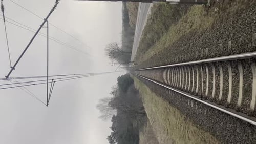Vertical View on Railroad Track From the Back Window of Fast Train Bullet Train Rides on the Railway