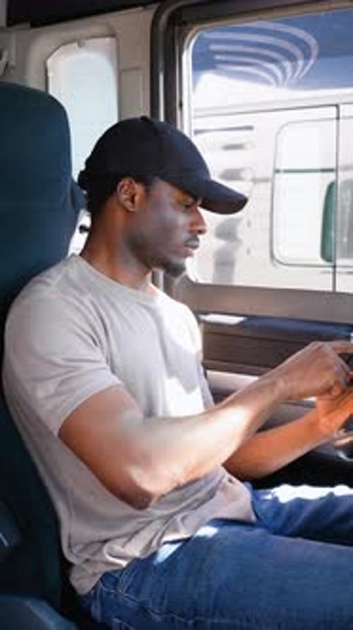 African American Truck Driver Using Truck Gps Navigation to Looks the Route Before Leaving Vertical