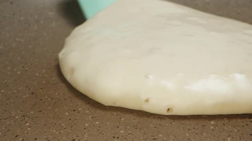 I turn the pancake over in a frying pan, with a silicone spatula. extreme close-up.